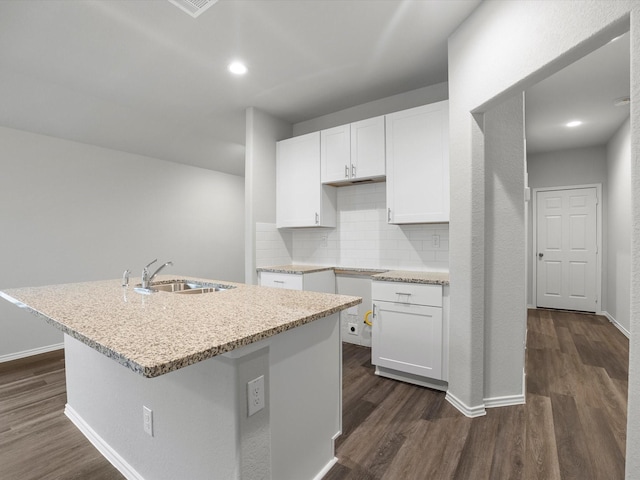 kitchen featuring sink, an island with sink, tasteful backsplash, dark hardwood / wood-style flooring, and white cabinetry