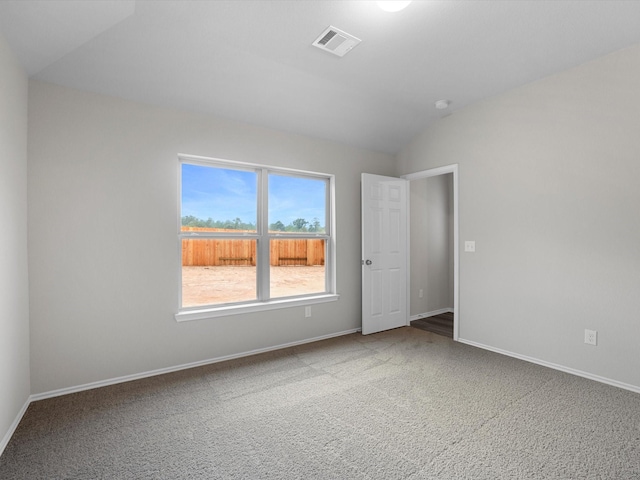 carpeted spare room with vaulted ceiling