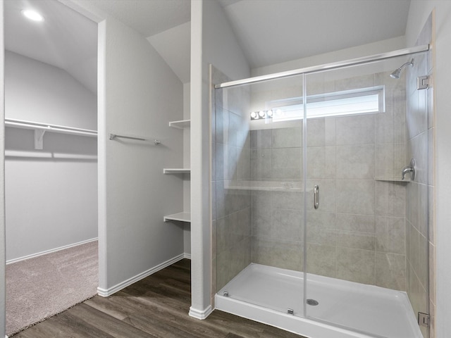 bathroom featuring hardwood / wood-style flooring, vaulted ceiling, and an enclosed shower