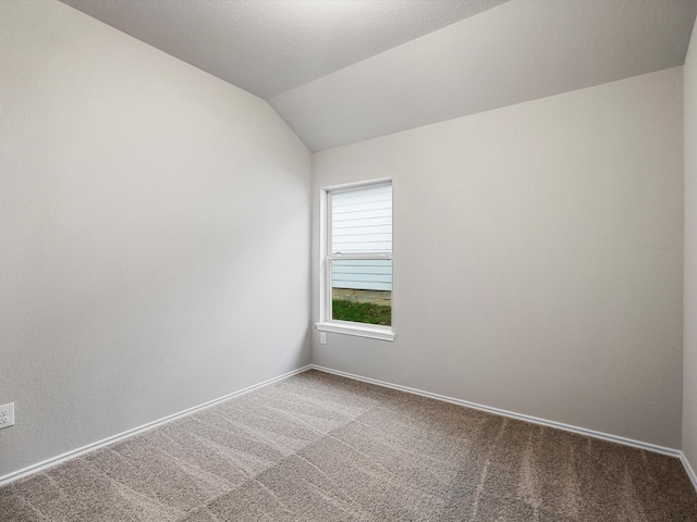 carpeted spare room featuring lofted ceiling