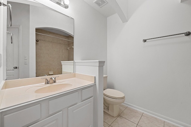 bathroom with tile patterned floors, vanity, toilet, and a tile shower