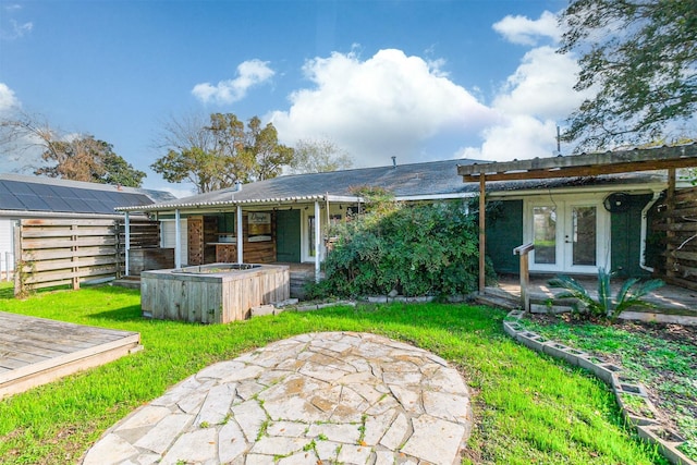 rear view of house with french doors, a patio, and a yard