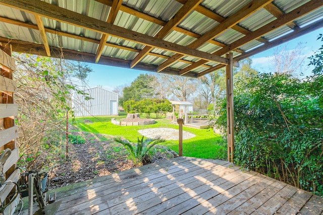 wooden deck with a lawn and an outbuilding