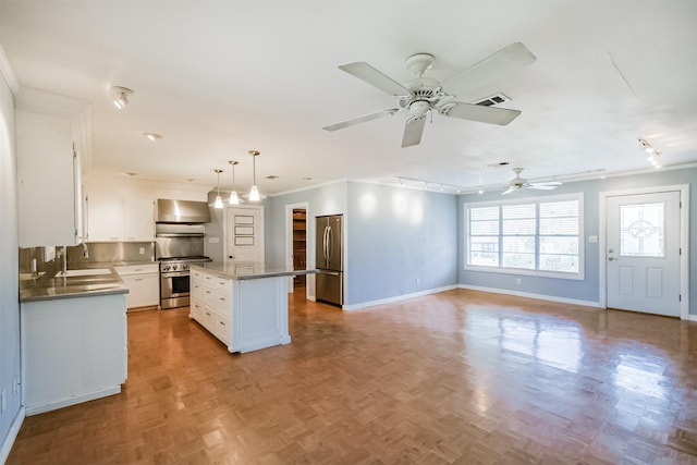 kitchen with a center island, white cabinets, ceiling fan, appliances with stainless steel finishes, and decorative light fixtures