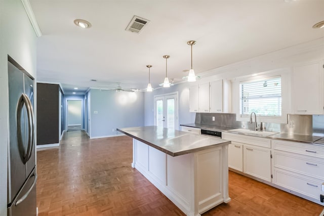 kitchen featuring stainless steel fridge, white cabinetry, ceiling fan, and sink