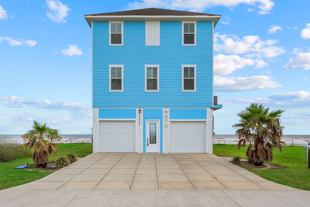 view of front facade featuring a water view, a front lawn, and a garage