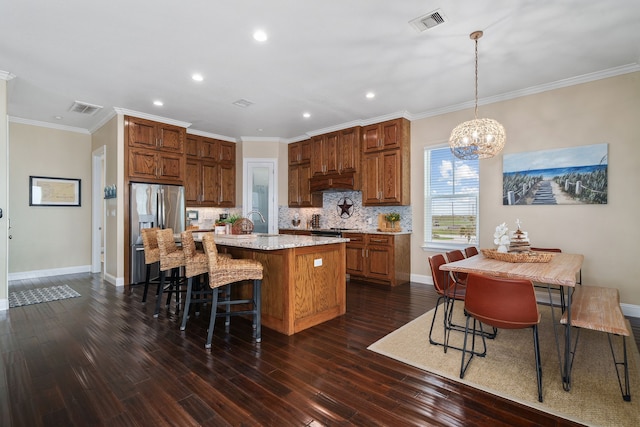 kitchen featuring ornamental molding, a center island, pendant lighting, and a notable chandelier