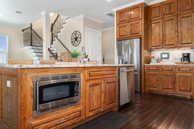 kitchen featuring backsplash, dark hardwood / wood-style floors, crown molding, and stainless steel appliances