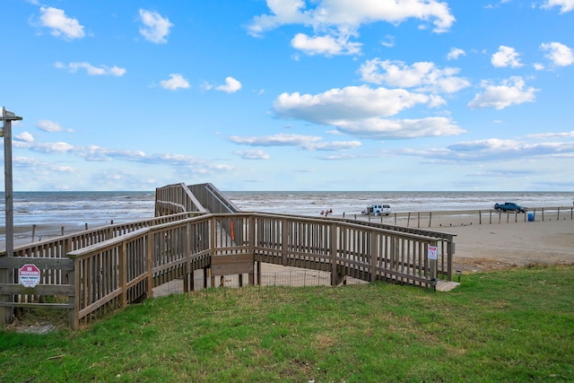 surrounding community featuring a water view, a beach view, and a yard