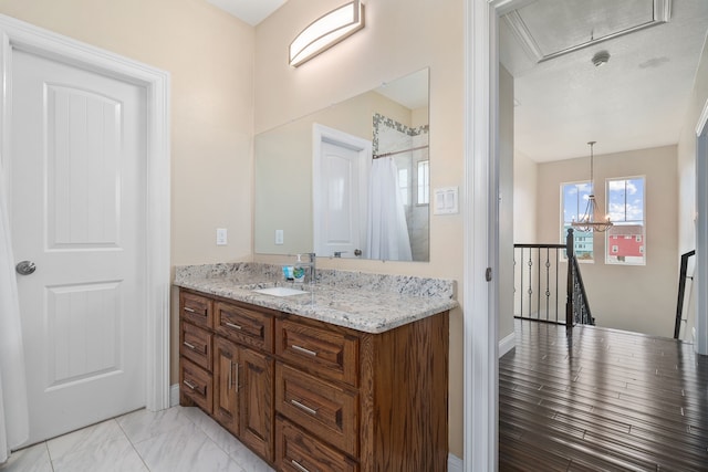 bathroom featuring a notable chandelier and vanity