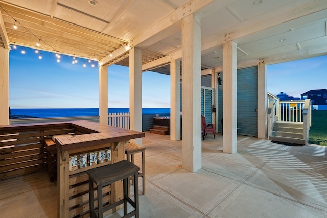 view of patio featuring a water view and a bar