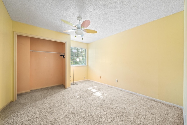 unfurnished bedroom with carpet flooring, ceiling fan, a textured ceiling, and a closet