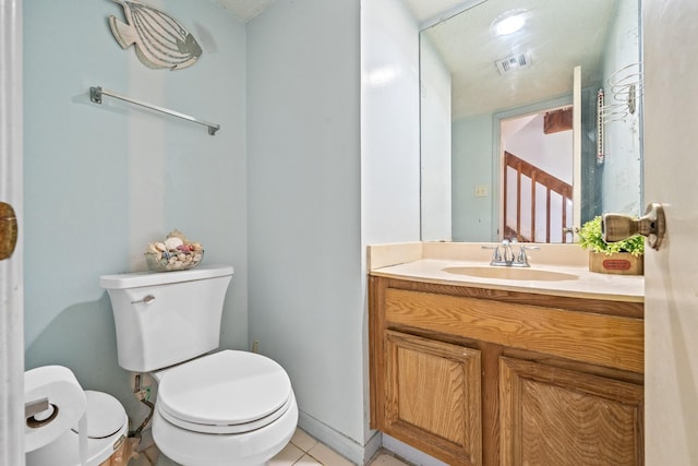 bathroom featuring tile patterned flooring, vanity, and toilet