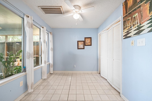 interior space with light tile patterned flooring and a textured ceiling