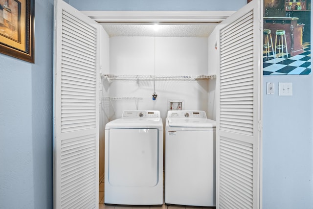 laundry room with washer and dryer and a textured ceiling