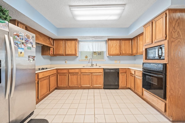 kitchen with a textured ceiling, sink, and black appliances