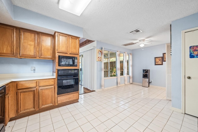 kitchen featuring light tile patterned floors, a textured ceiling, ceiling fan, and black appliances