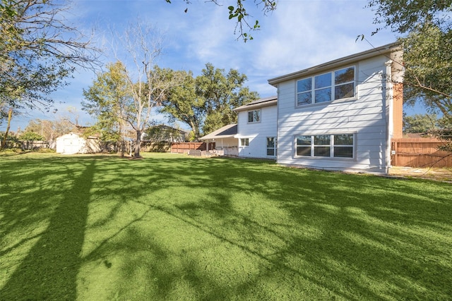 rear view of property with a yard and a shed