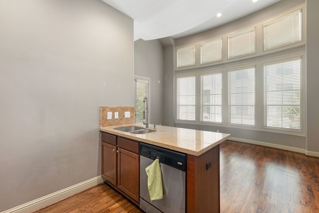 kitchen featuring dishwasher, kitchen peninsula, tasteful backsplash, and sink