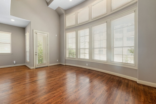 empty room featuring dark hardwood / wood-style floors and a high ceiling