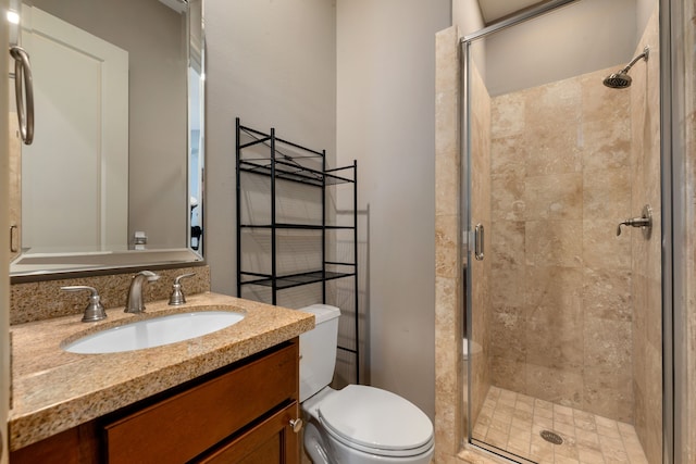 bathroom featuring vanity, toilet, and an enclosed shower