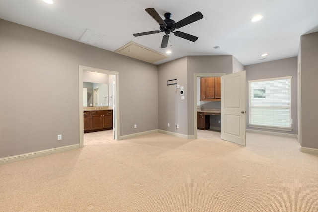 unfurnished bedroom with light carpet, ensuite bathroom, and ceiling fan