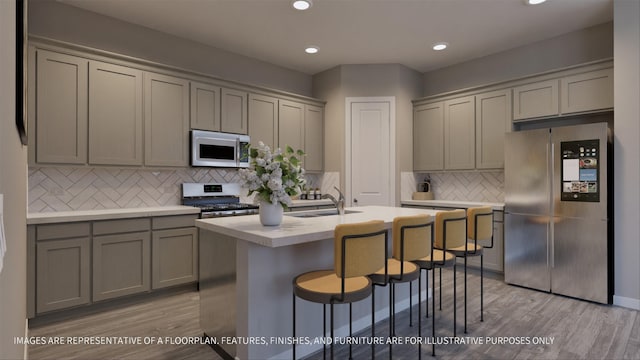 kitchen with sink, stainless steel appliances, light hardwood / wood-style floors, and tasteful backsplash