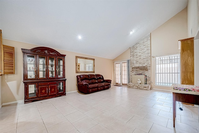 living area featuring a fireplace, light tile patterned floors, and high vaulted ceiling