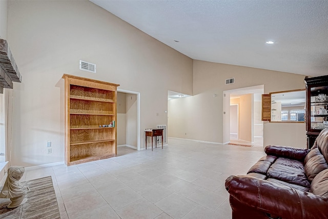 tiled living room featuring a textured ceiling and high vaulted ceiling