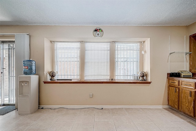 tiled dining space featuring a wealth of natural light and a textured ceiling