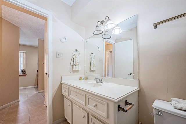 bathroom with tile patterned floors, vanity, a textured ceiling, and toilet