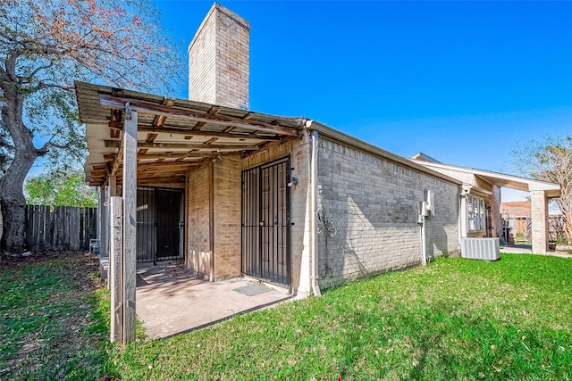 back of house with a yard and central AC unit