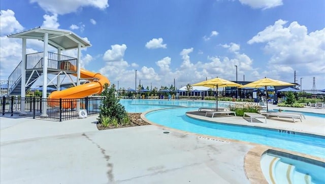 view of pool with a water slide and a patio