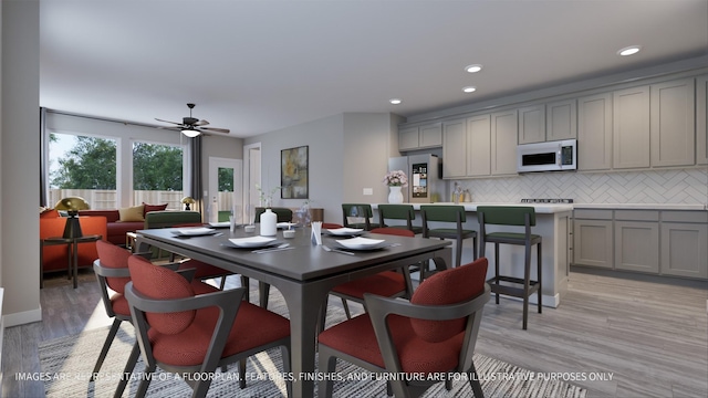 dining space with ceiling fan and light wood-type flooring