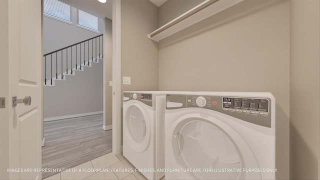 clothes washing area featuring washing machine and dryer and light tile patterned floors