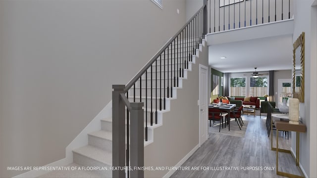 stairs with hardwood / wood-style floors and ceiling fan