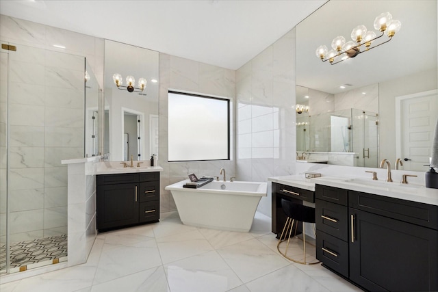 full bathroom featuring a stall shower, tile walls, an inviting chandelier, and a sink