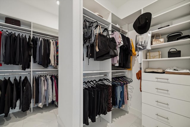 walk in closet featuring marble finish floor