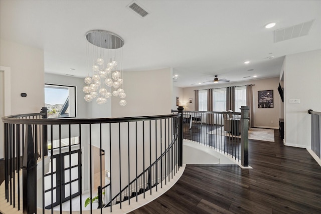 hallway with a wealth of natural light, visible vents, and an upstairs landing