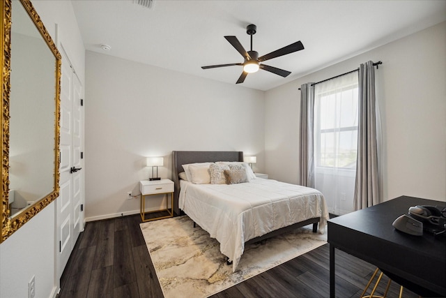 bedroom featuring a ceiling fan, visible vents, dark wood-style floors, and baseboards