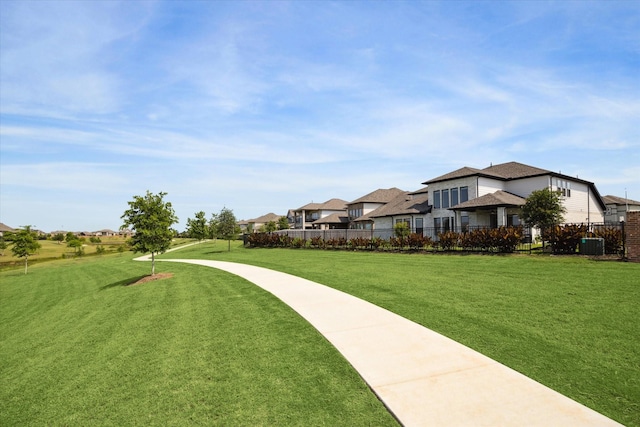 view of home's community featuring a yard, a residential view, and fence