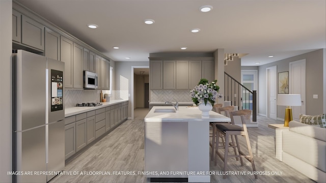 kitchen with stainless steel appliances, gray cabinets, and decorative backsplash