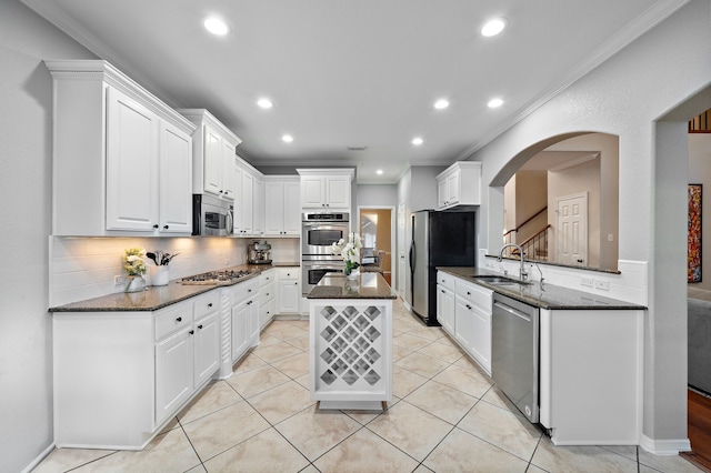 kitchen featuring a center island, white cabinets, sink, decorative backsplash, and stainless steel appliances