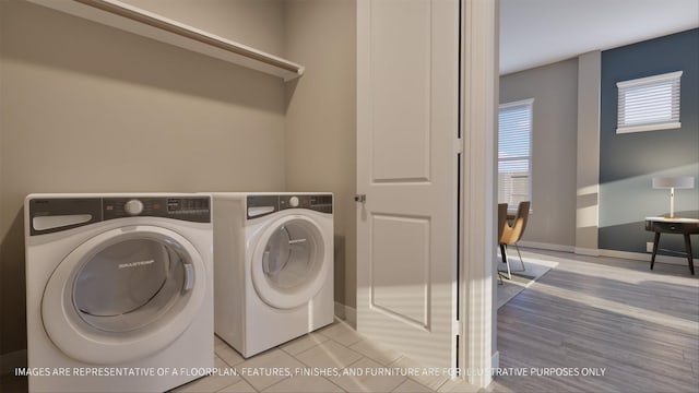 laundry area featuring washing machine and clothes dryer and light tile patterned floors