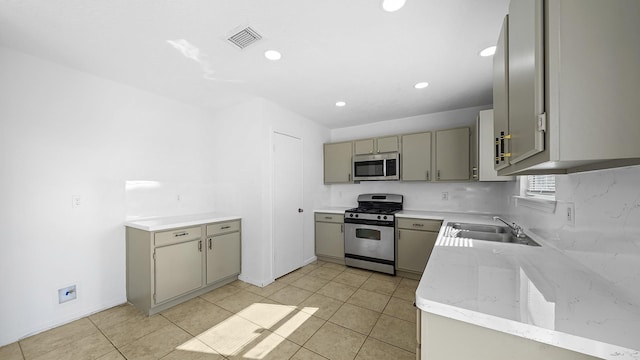 kitchen featuring appliances with stainless steel finishes, gray cabinets, light tile patterned floors, and sink