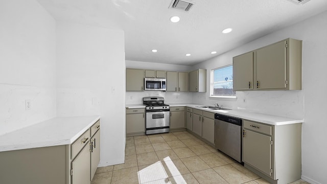 kitchen featuring gray cabinets, sink, light tile patterned floors, and appliances with stainless steel finishes