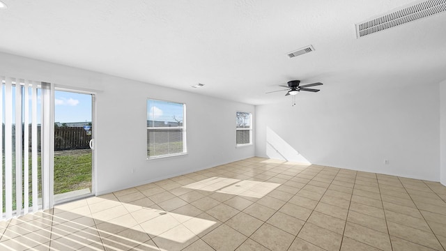 tiled empty room featuring ceiling fan