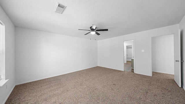 carpeted empty room with ceiling fan and a textured ceiling