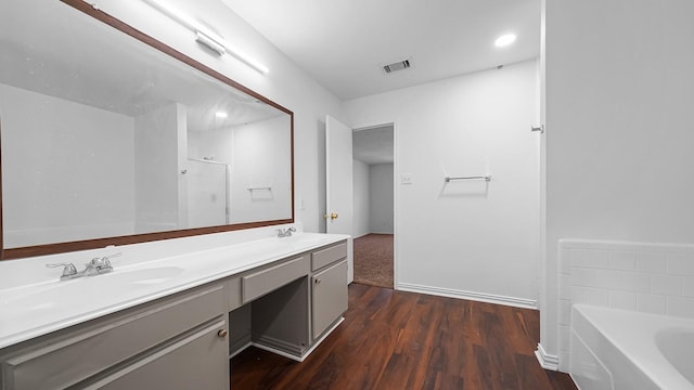 bathroom with a bathtub, wood-type flooring, and vanity