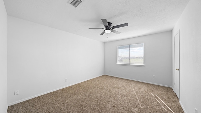 carpeted spare room featuring ceiling fan and a textured ceiling